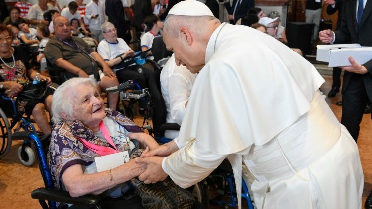 Il Papa saluta una donna anziana e malata nella Cattedrale di Rimini